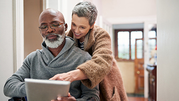 A senior couple looking at a tablet computer together.